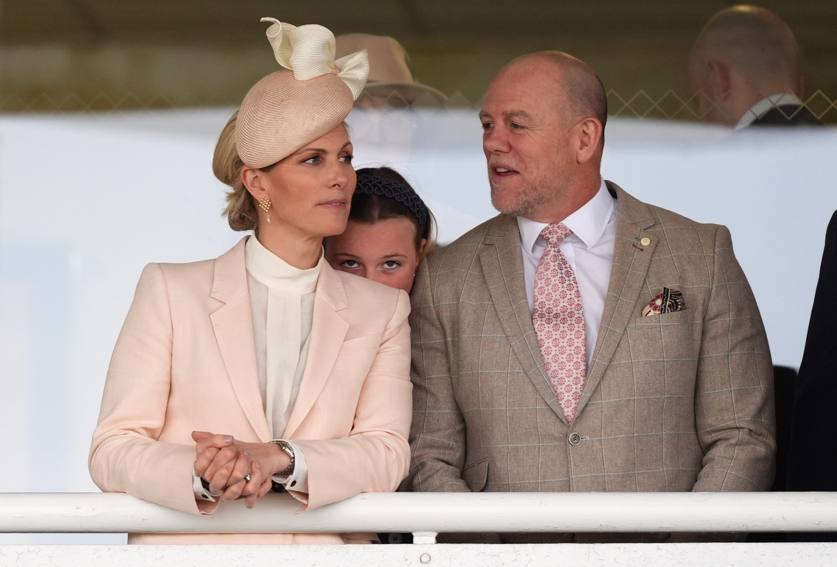 In a softer, more intimate exchange, Zara Tindall turned slightly towards Mike Tindall as he spoke, while Mia Tindall peeked out between them &mdash; a subtle family interaction that balanced the public spectacle with a private, affectionate dynamic.