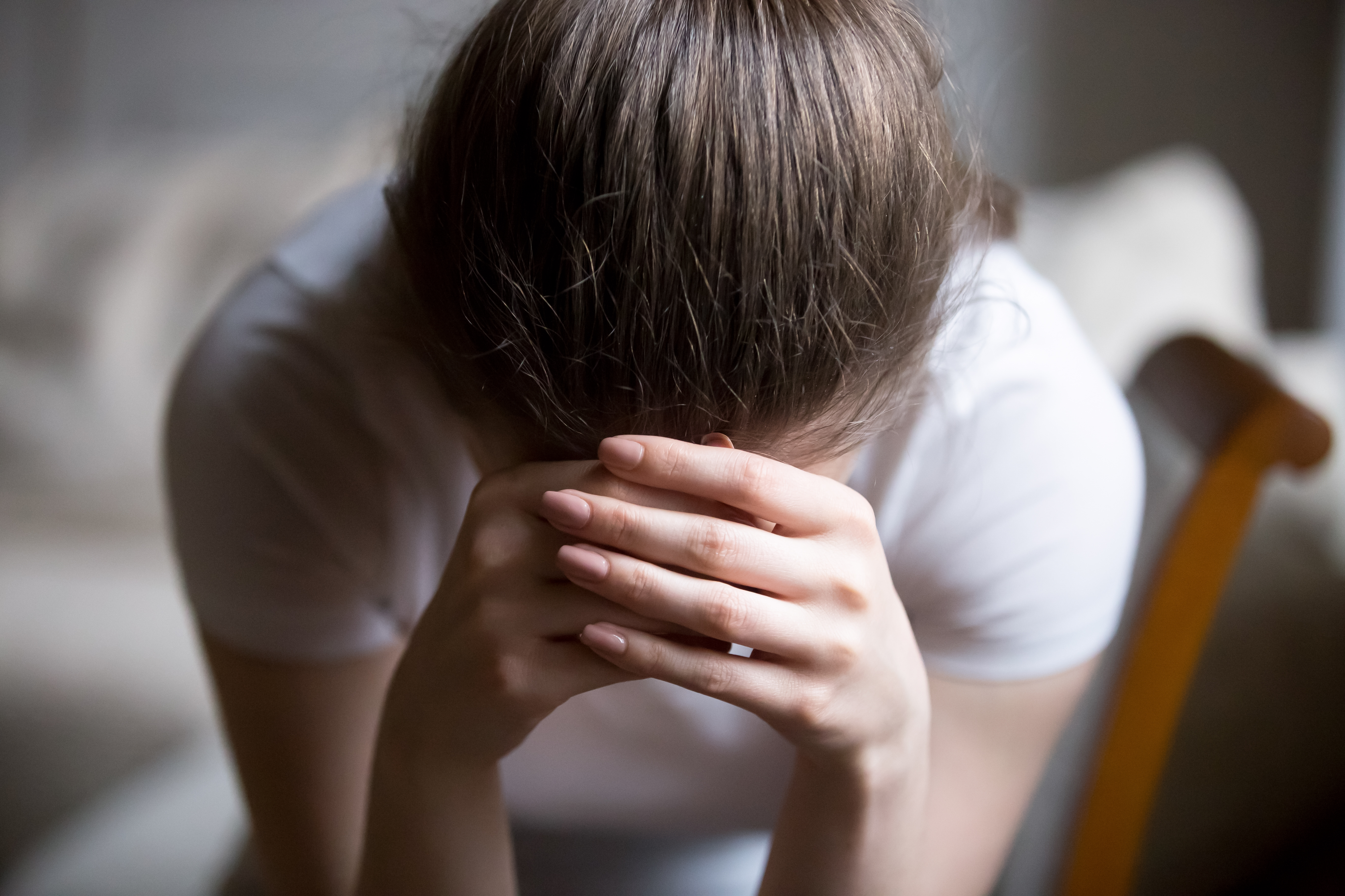A depressed young woman crying at home | Source: Shutterstock