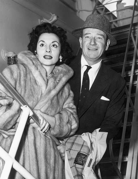 Photo of John Wayne and Pilar Palette in 1956. | Photo: Getty Images