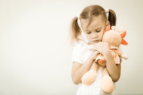 Niña abranzando su peluche| Imagen: Shutterstock