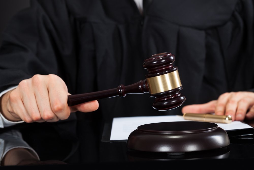 Nahaufnahme des männlichen Richters mit Richterhammer am Schreibtisch