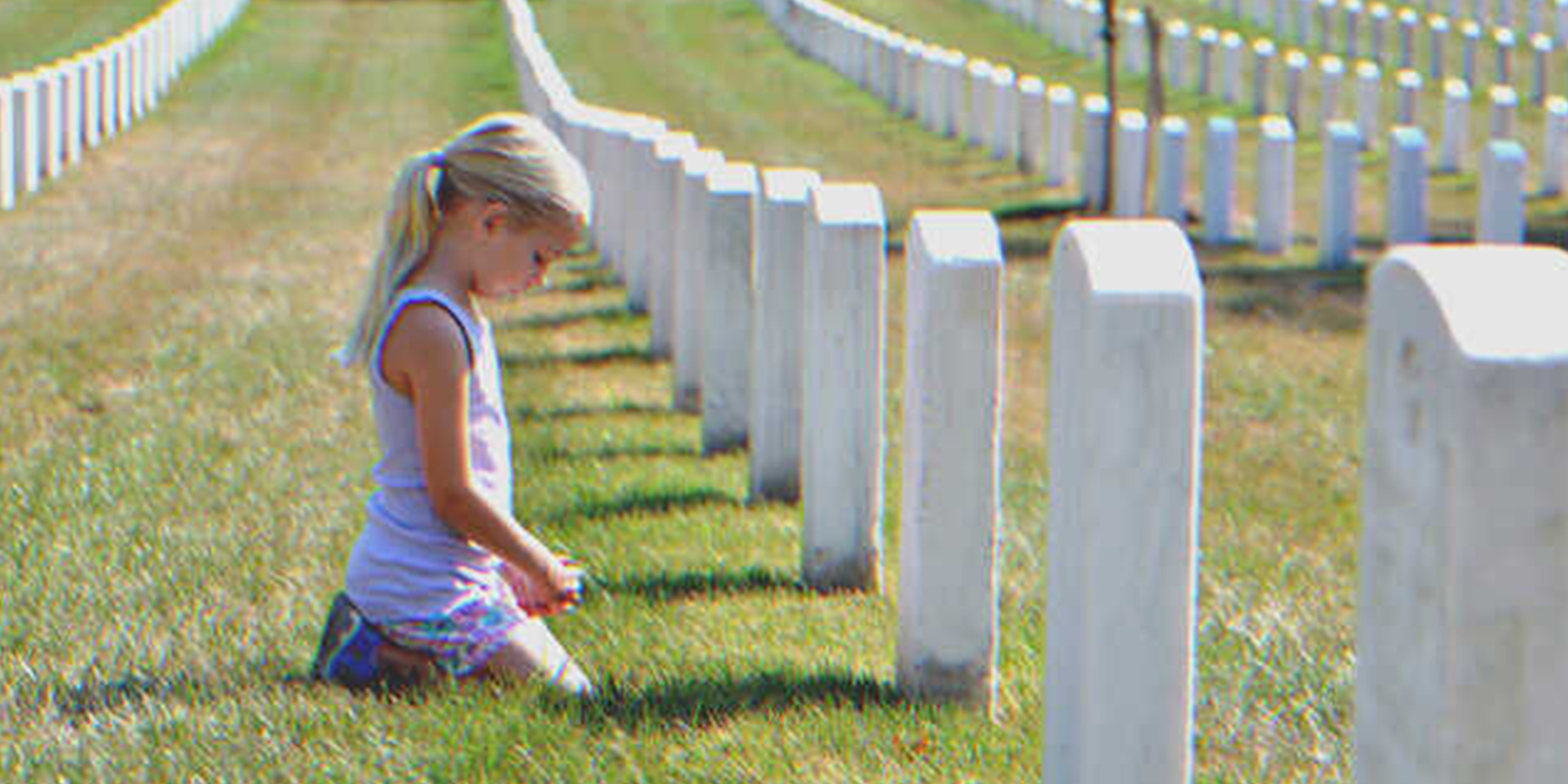 Mädchen kniet vor einem Grabstein | Quelle: Shutterstock