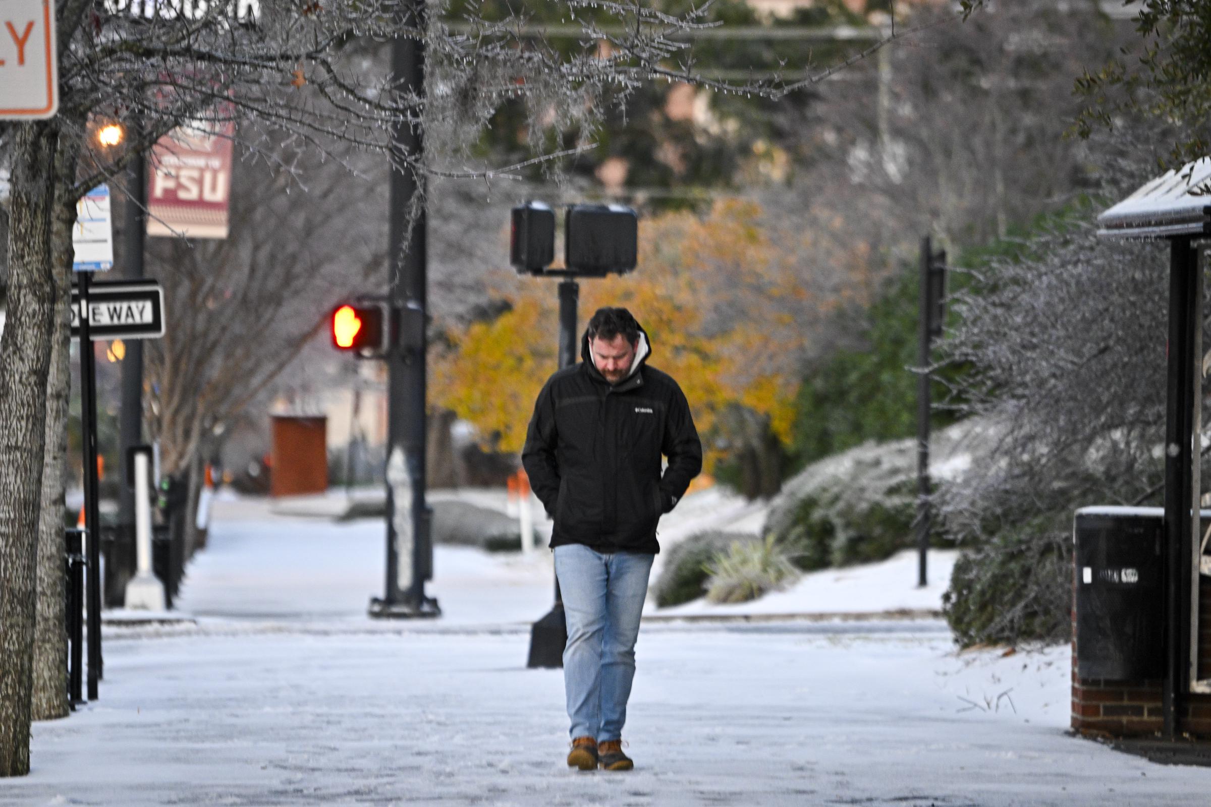 A person walks on snow after snowfall on January 22, 2025, in Tallahassee, Florida | Source: Getty Images