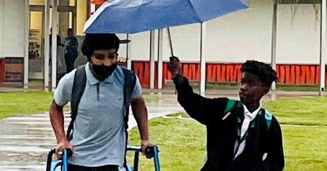 Lamar and his schoolmate Jerry Hernandez sharing an umbrella | Photo:  facebook.com/MattDevittWeather