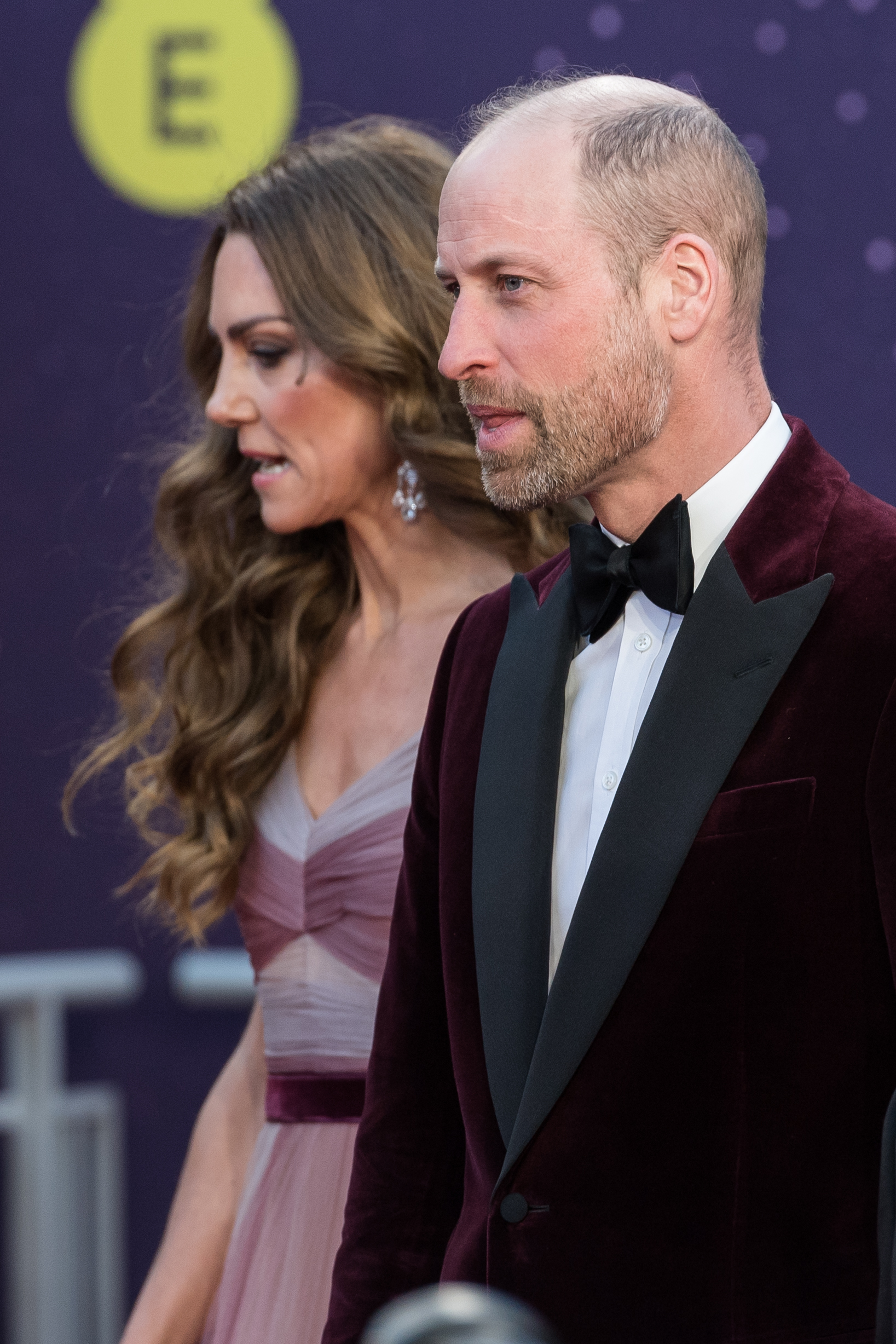 A closer view revealed the Prince of Wales's black bow tie set against a crisp white shirt, contrasting with the plush texture of his velvet blazer. Just behind him, the Princess of Wales's loose waves fell over her shoulders, her layered bodice blending rose and mauve tones in a subtle gradient.