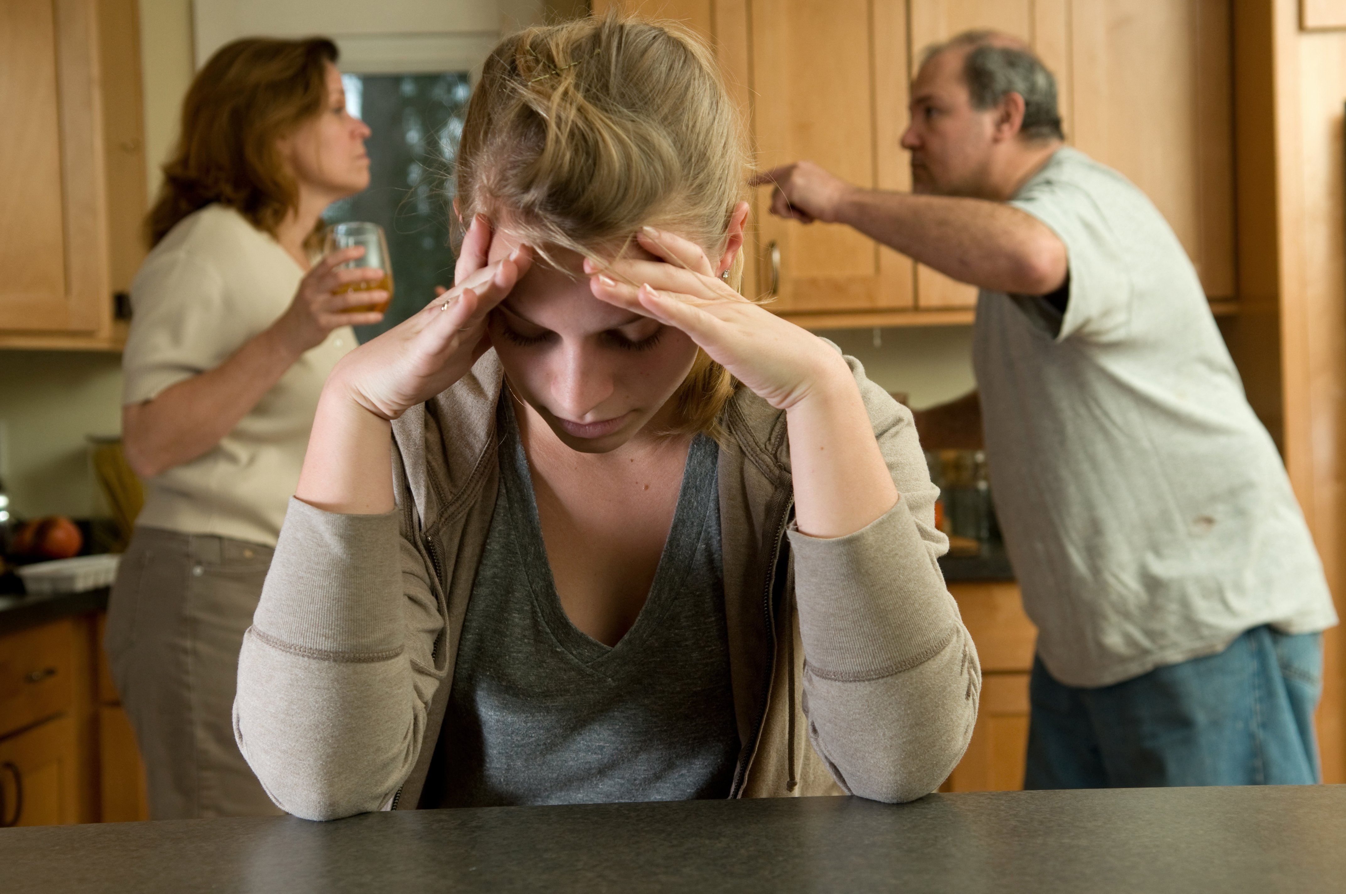 A young woman struggles to listen to her parents fight | Source: Shutterstock