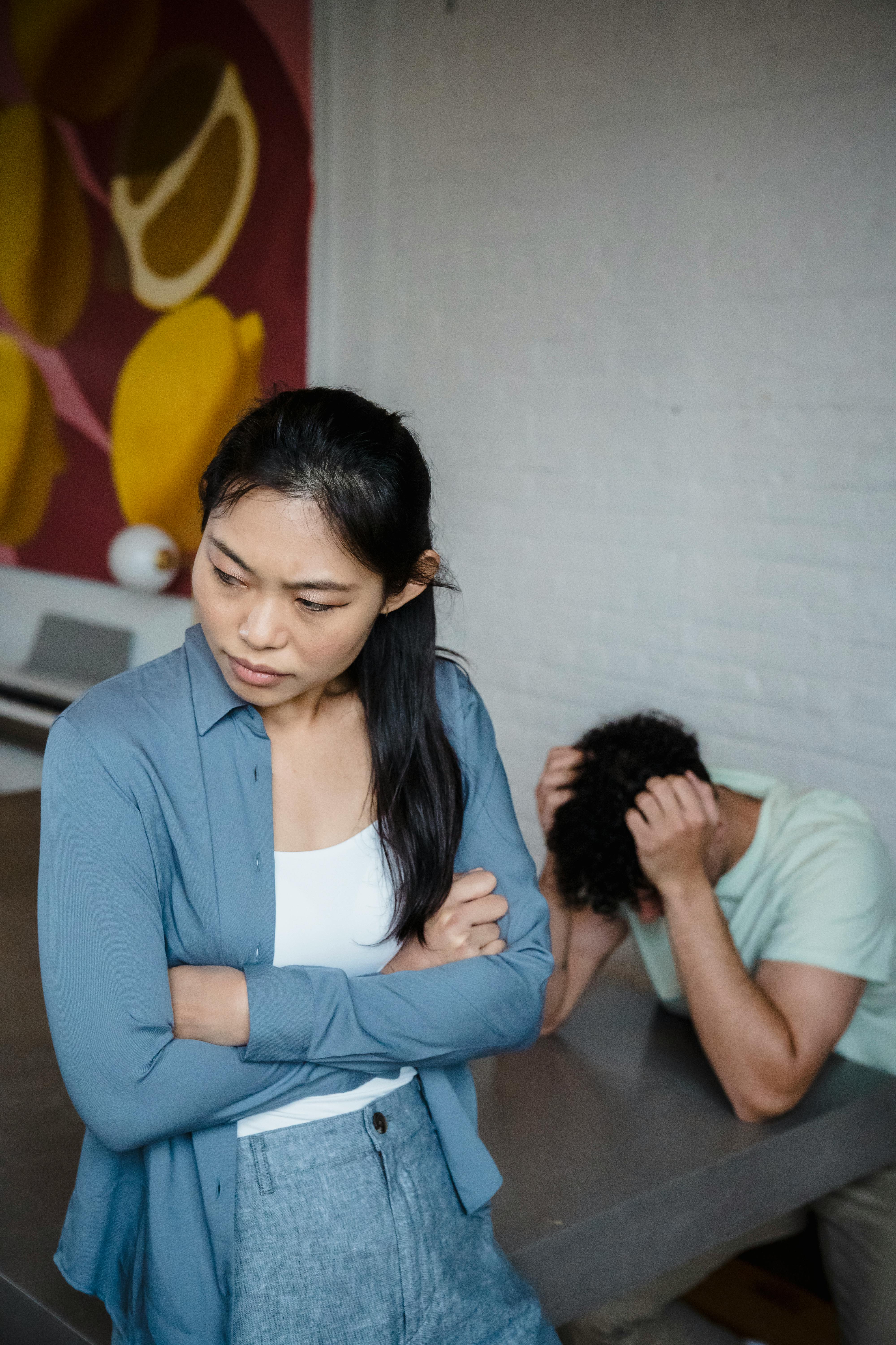 A woman and a man burying his head in his hands | Source: Pexels