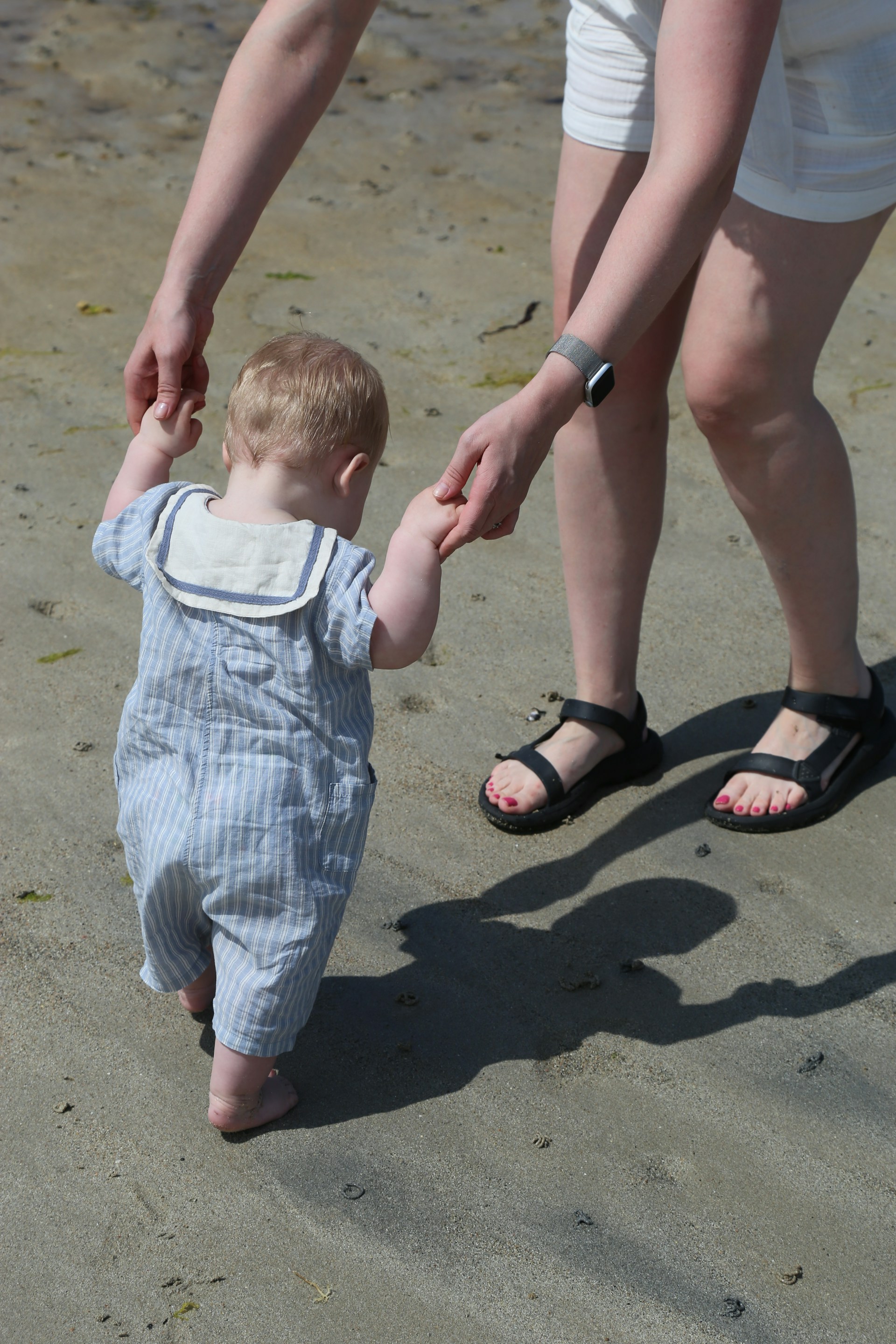 A mother guiding a toddler to walk | Source: Unsplash