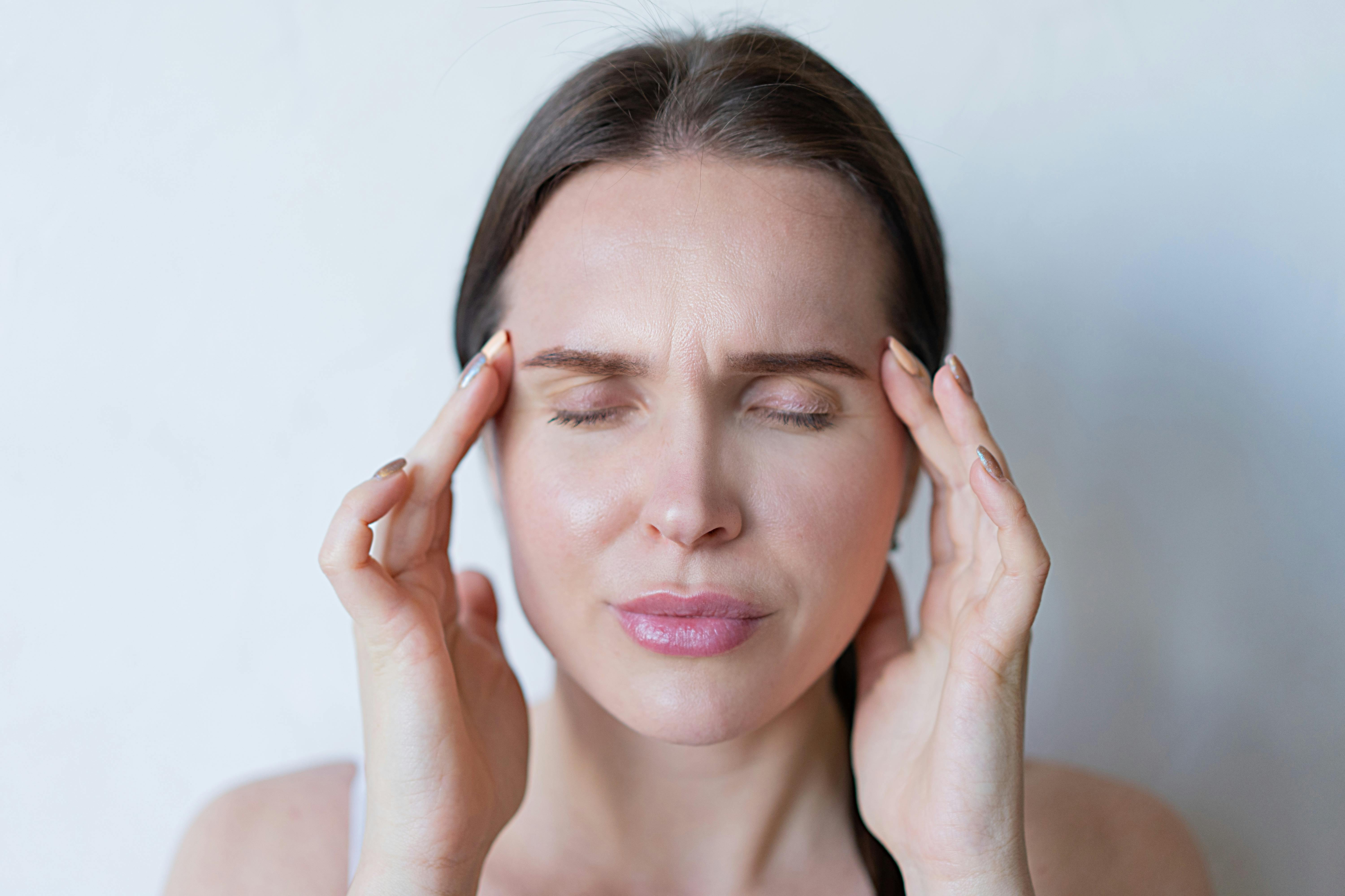 A woman rubbing her temples | Source: Pexels