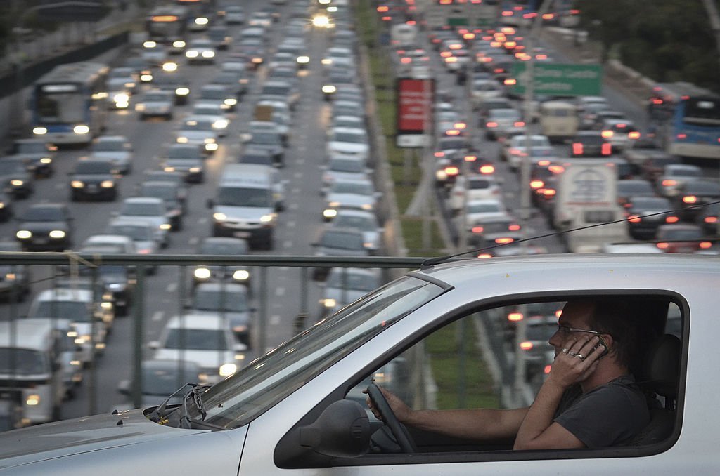 A man talks on his cellphone while driving on a highway on September 20, 2013 | Photo: Getty Images