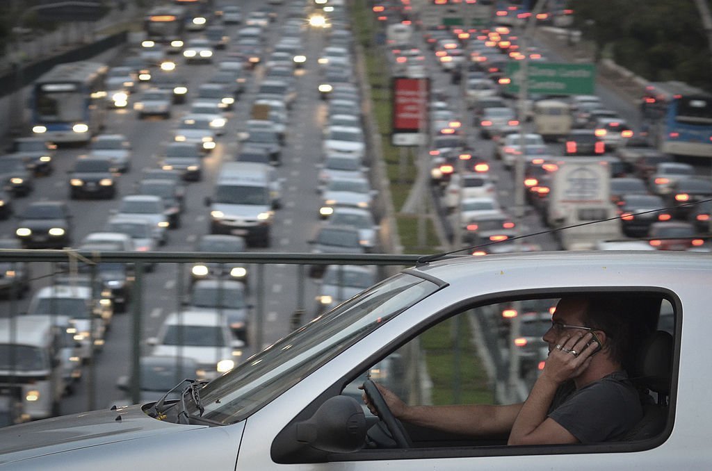 A man talks on his cellphone while driving on a highway on September 20, 2013, in Sao Paulo, Brazil | Source: Getty Images