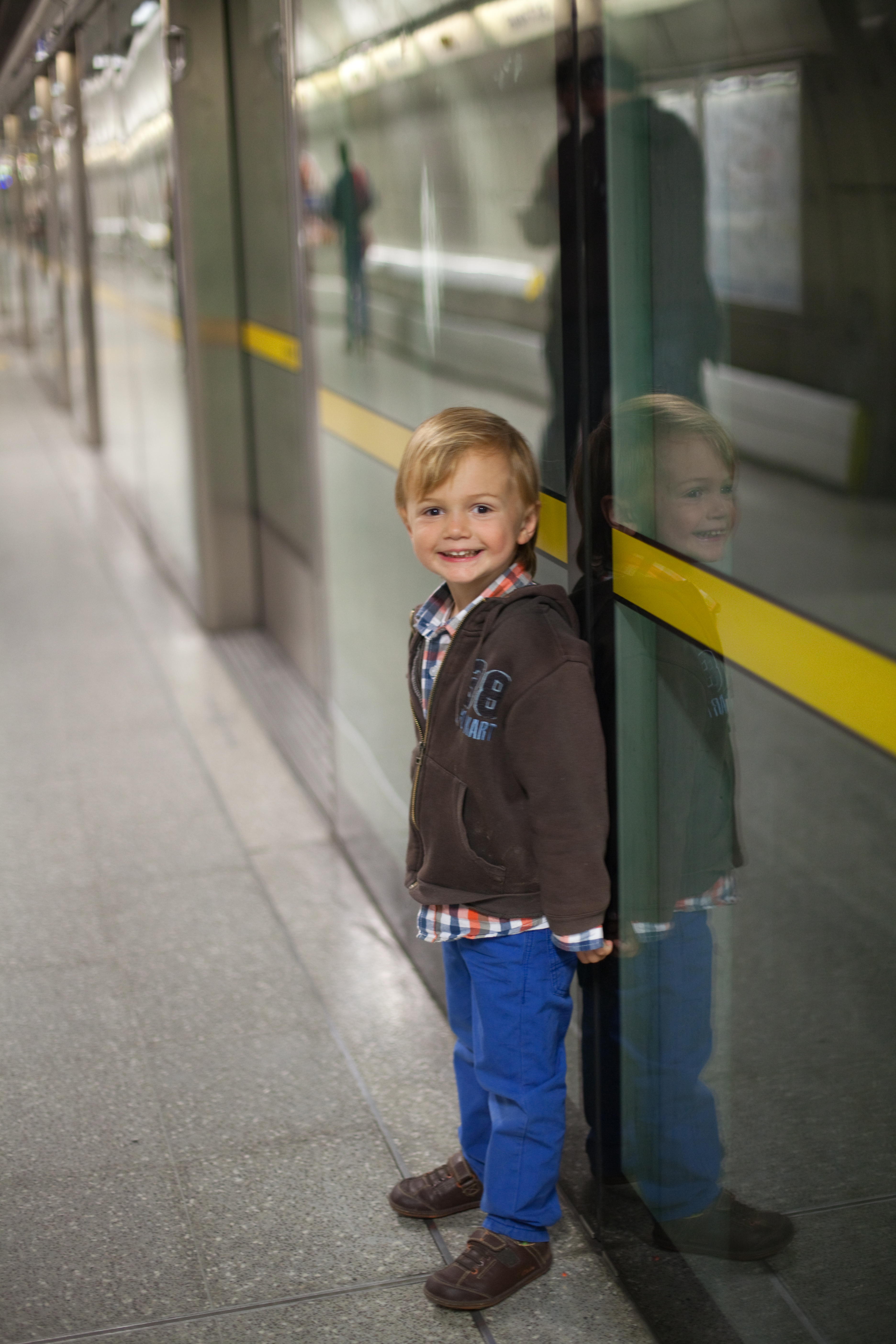 Smiling boy is waiting for train inside underground station in London. | Source: Getty Images