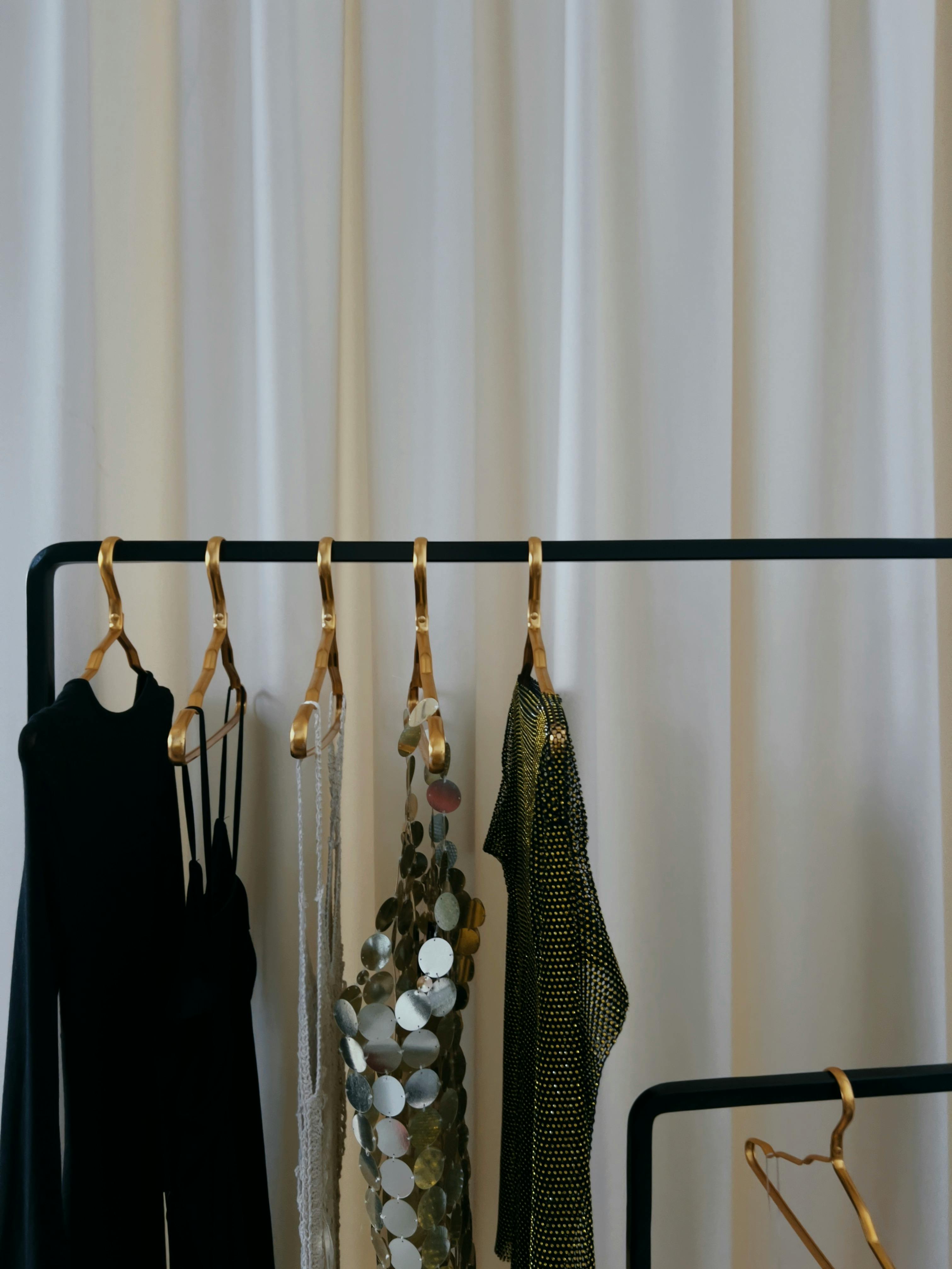 Little black dresses hanging from a pole | Source: Pexels
