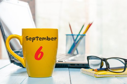 Día 6 de septiembre grabado en una taza de café amarilla. | Fuente: Shutterstock