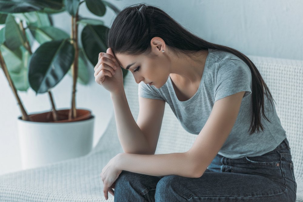 A frustrated young woman sitting on a couch | Photo: Shutterstock