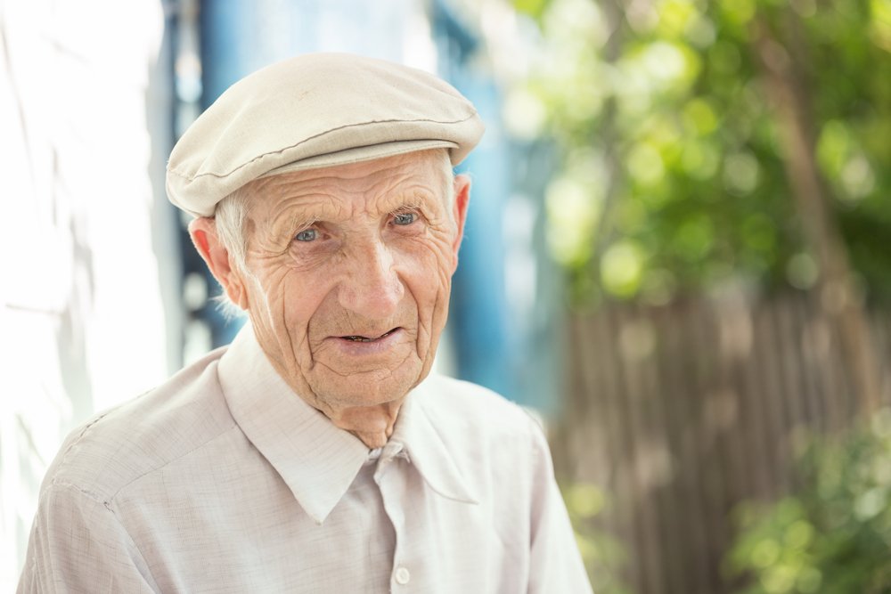 Retrato de hombre mayor sentado cerca de su casa en el pueblo. | Fuente: Shutterstock