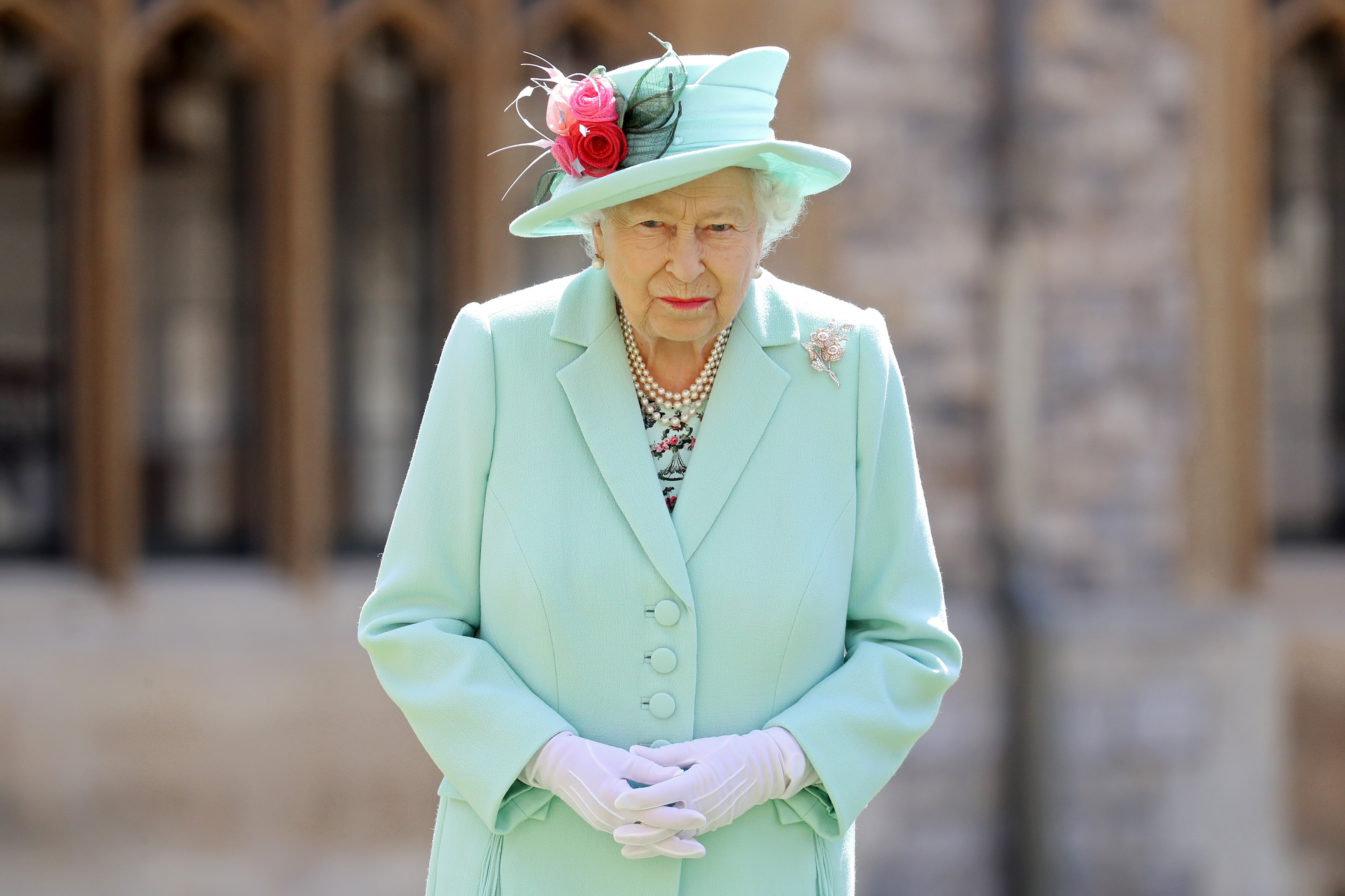 Queen Elizabeth II poses after awarding Captain Sir Thomas Moore with the insignia of Knight Bachelor at Windsor Castle on July 17, 2020 in Windsor, England | Photo: Getty Images