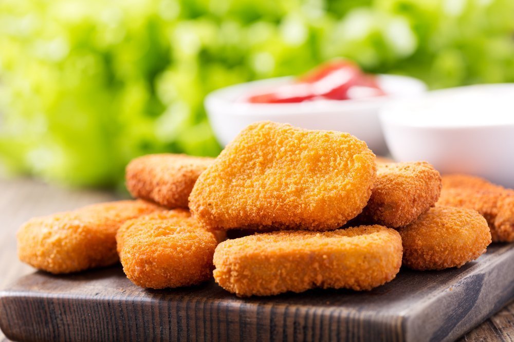 Chicken nuggets with sauces on wooden board. | Photo: Shutterstock