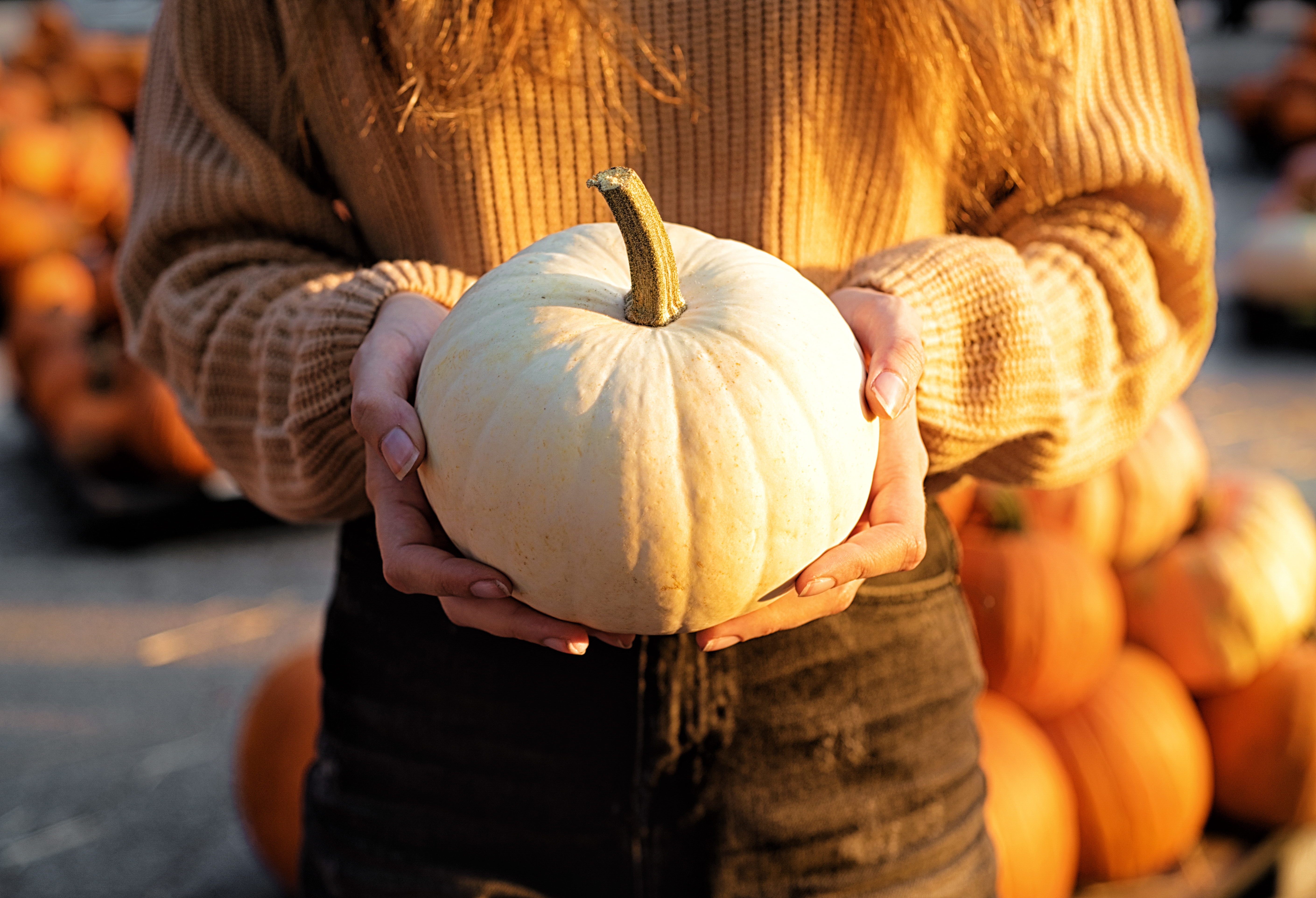 A woman holding a white pumpkin | Source: Getty Images