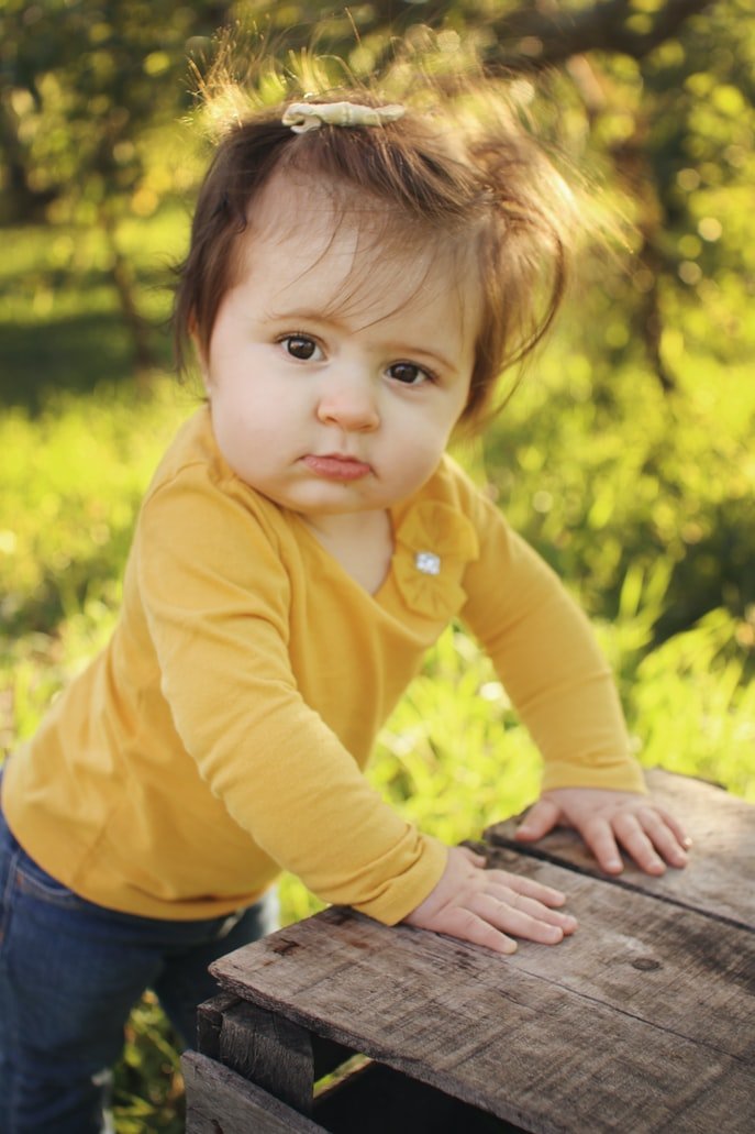 Una niña pequeña en la banca de un parque. | Foto: Unsplash