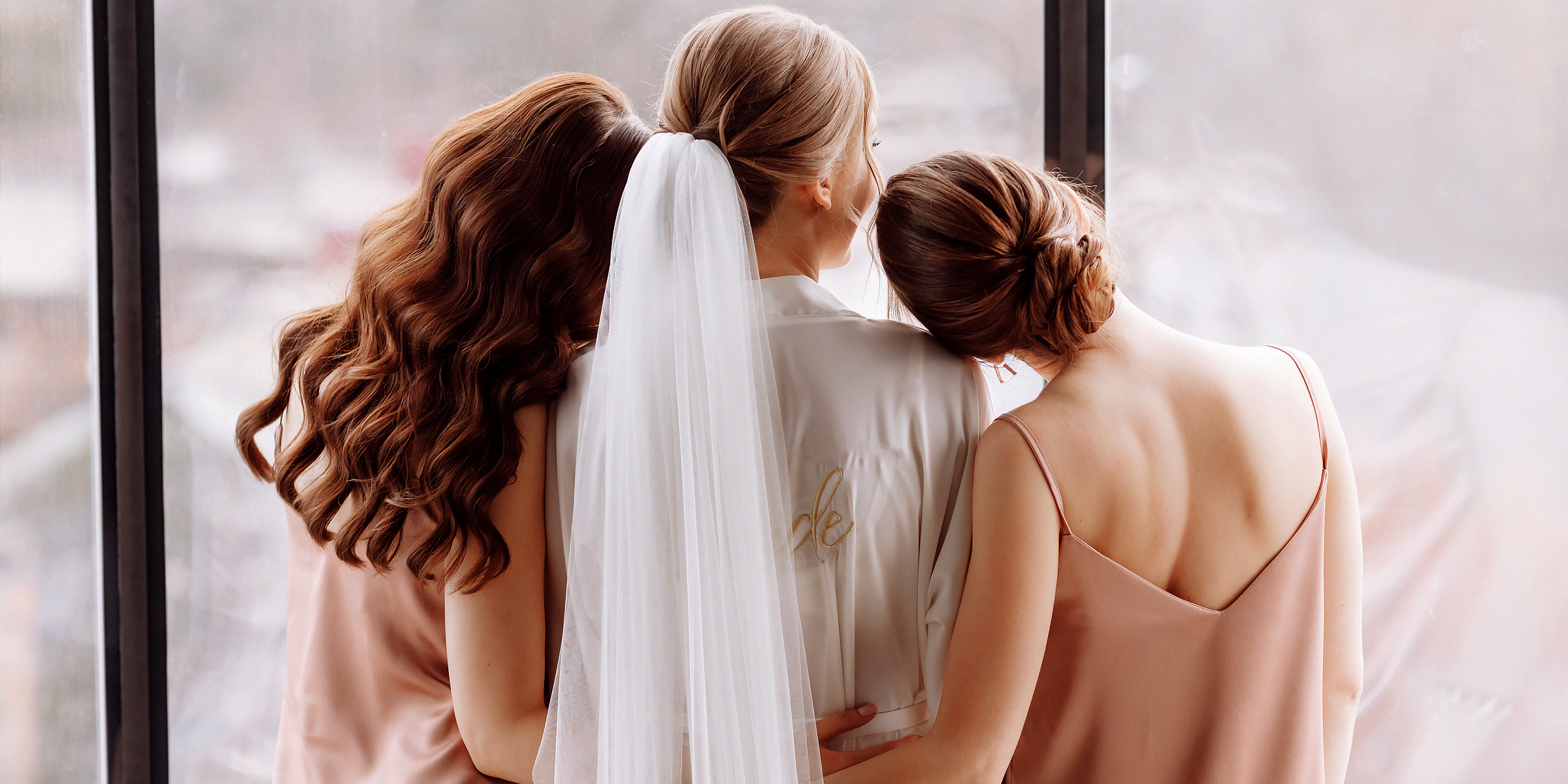 Bride hugging her bridesmaids. | Source: Shutterstock