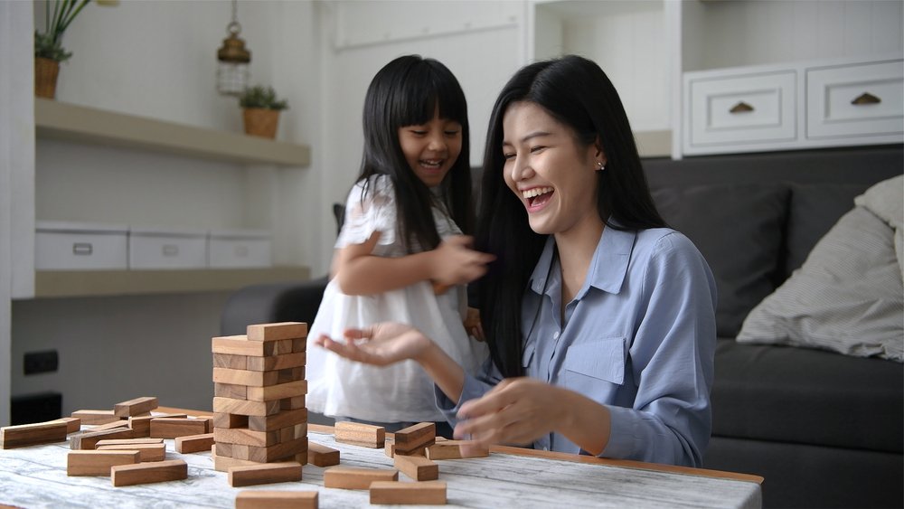 A mother and daughter playing games together in the house | Photo: Shutterstock/Sellwell