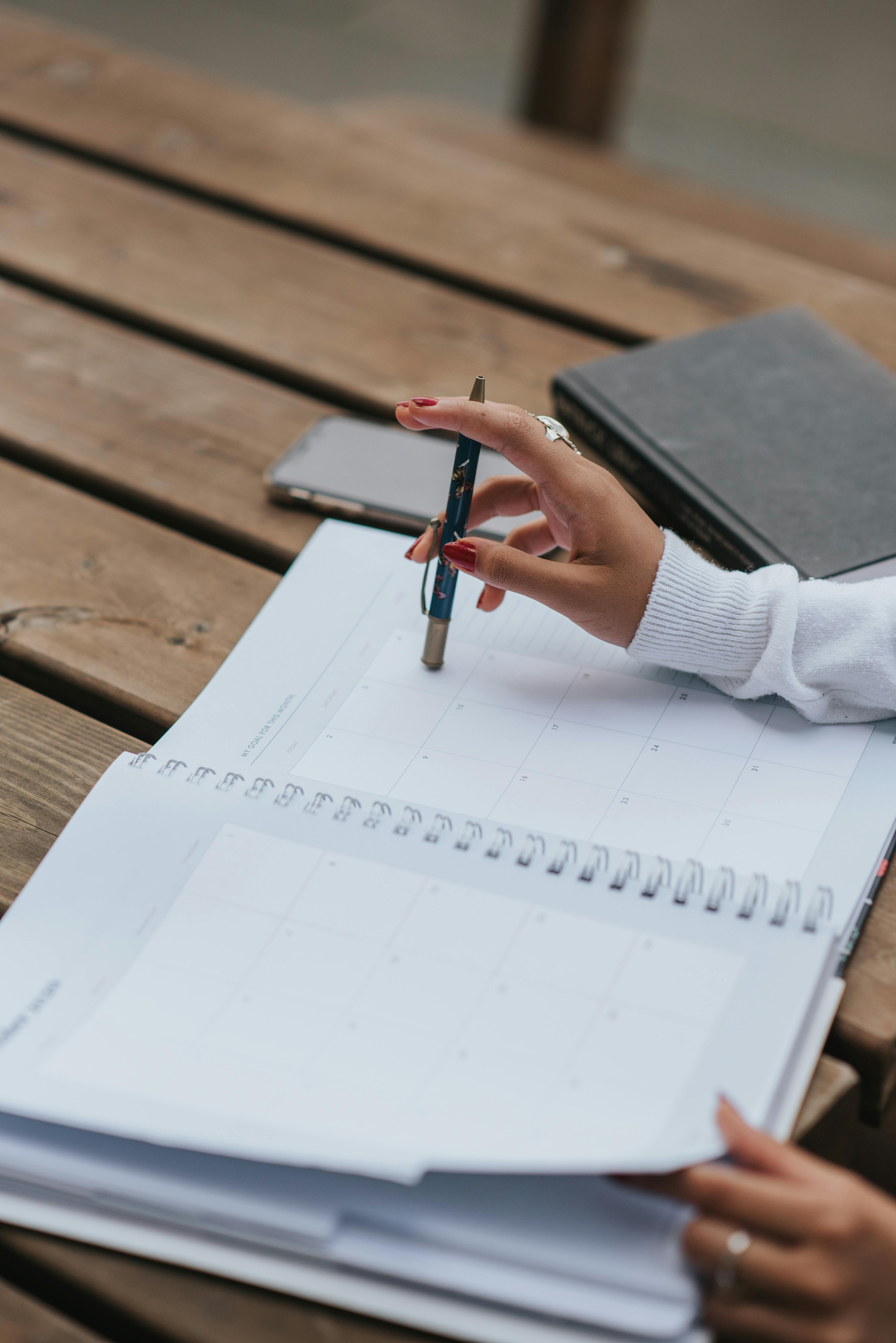 A closeup of a woman's hands on top of her diary | Source: Pexels