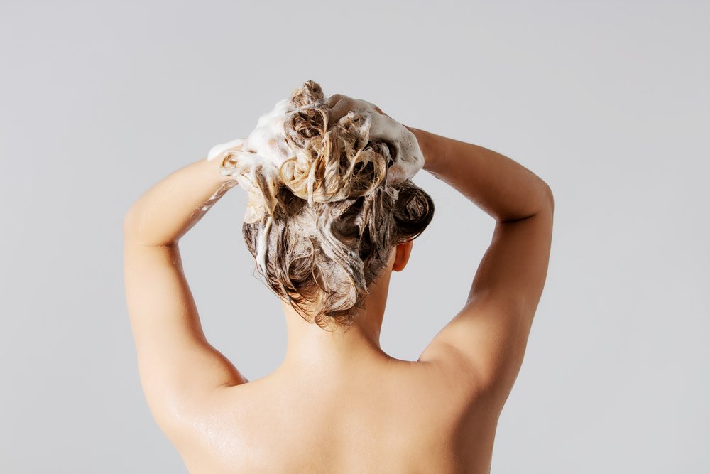 Frau, die ihre blonden Haare wäscht | Quelle: Shutterstock