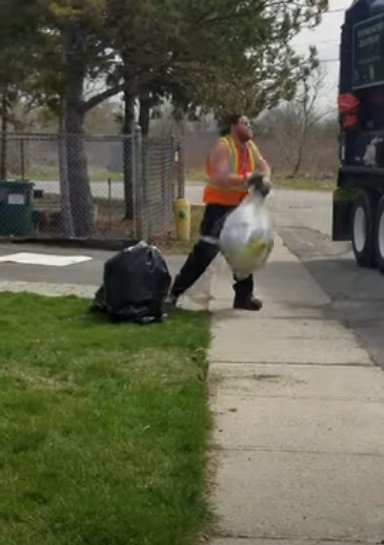 Trabajador del aseo lleva una bolsa de desperdicios al camión.| Foto: Youtube/ViralHog
