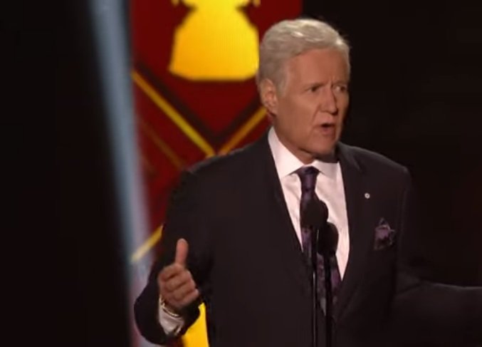 Alex Trebek presenting an award on stage at the NFL Awards.| Photo: YouTube/ NFL.