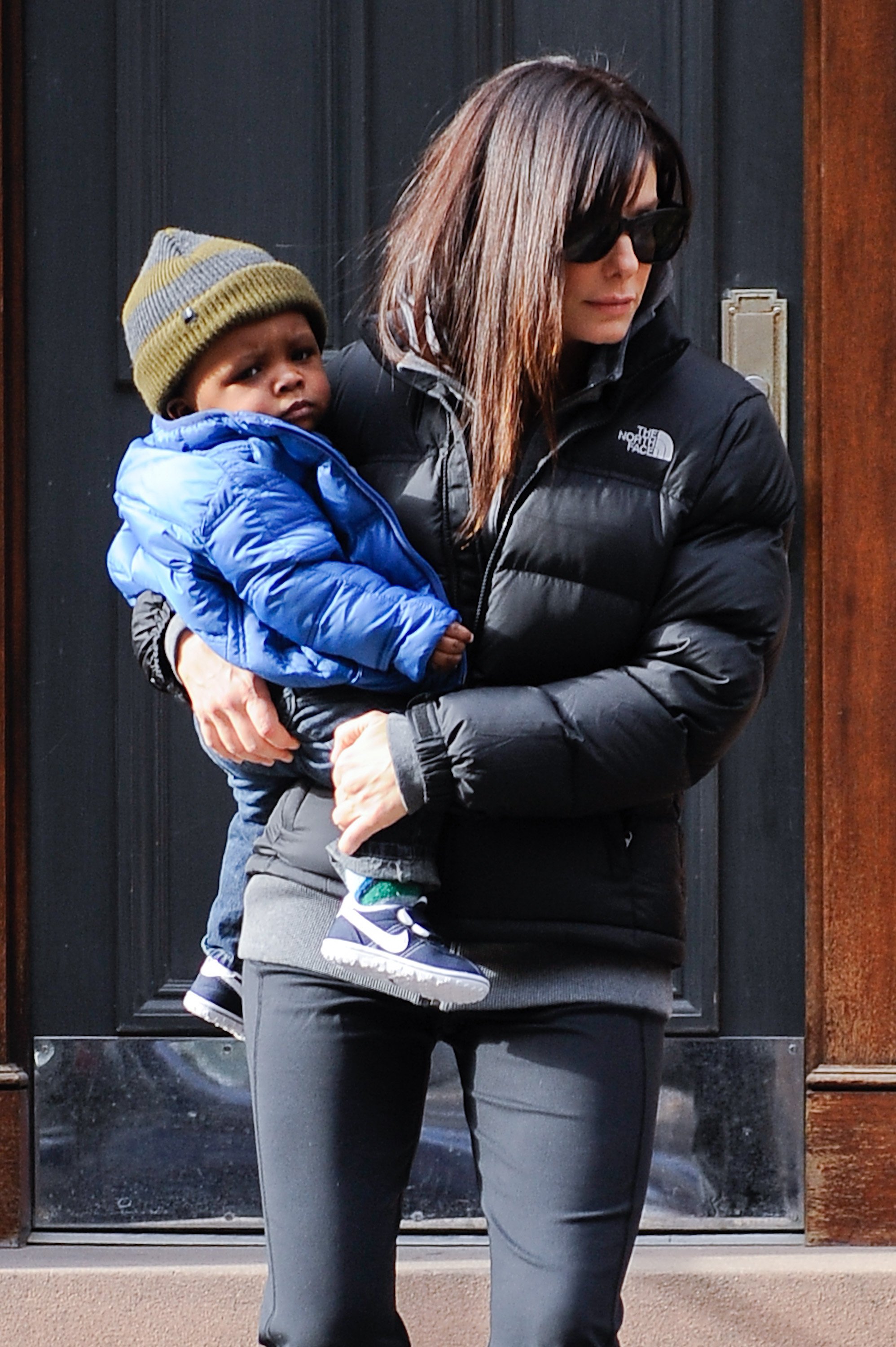 Sandra Bullock walking in public holding one of her children | Photo: Getty Images
