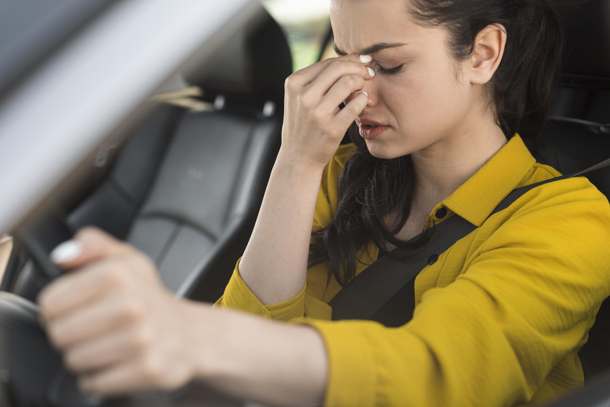 A distressed woman driving a car | Source: Freepik