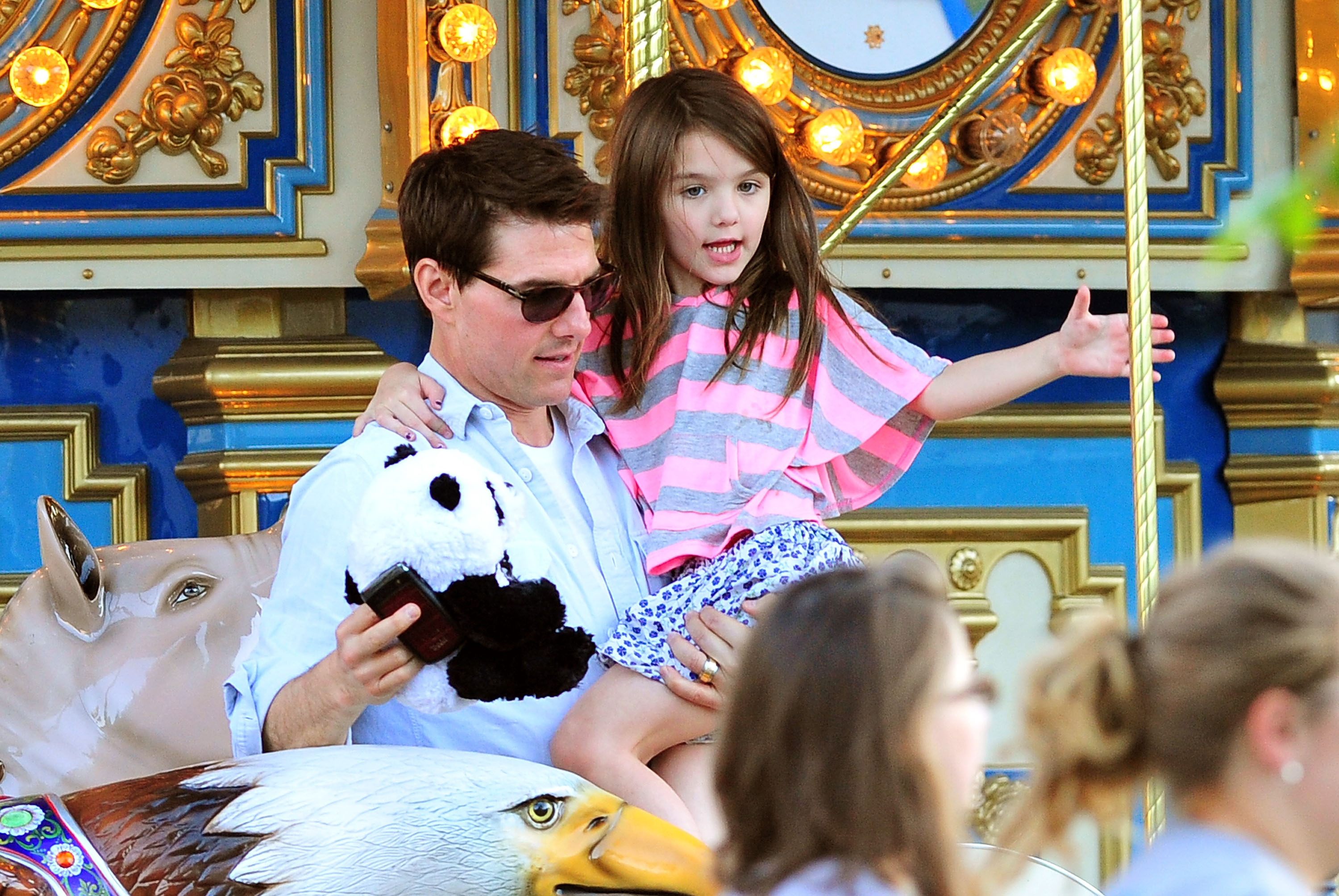 Tom Cruise and Suri Cruise enjoy a ride on the carousel at Schenley Plaza during an outing in Pittsburgh, Pennsylvania. | Source: Getty Images