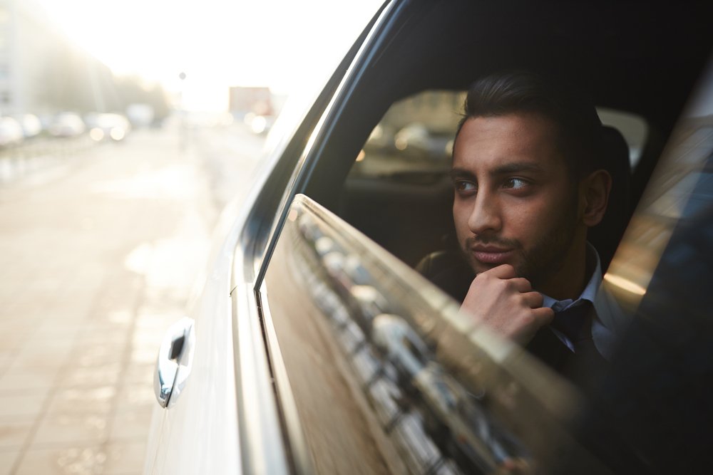 A photo of a man seating in the owner's corner of a luxurious car | Photo: Shutterstock