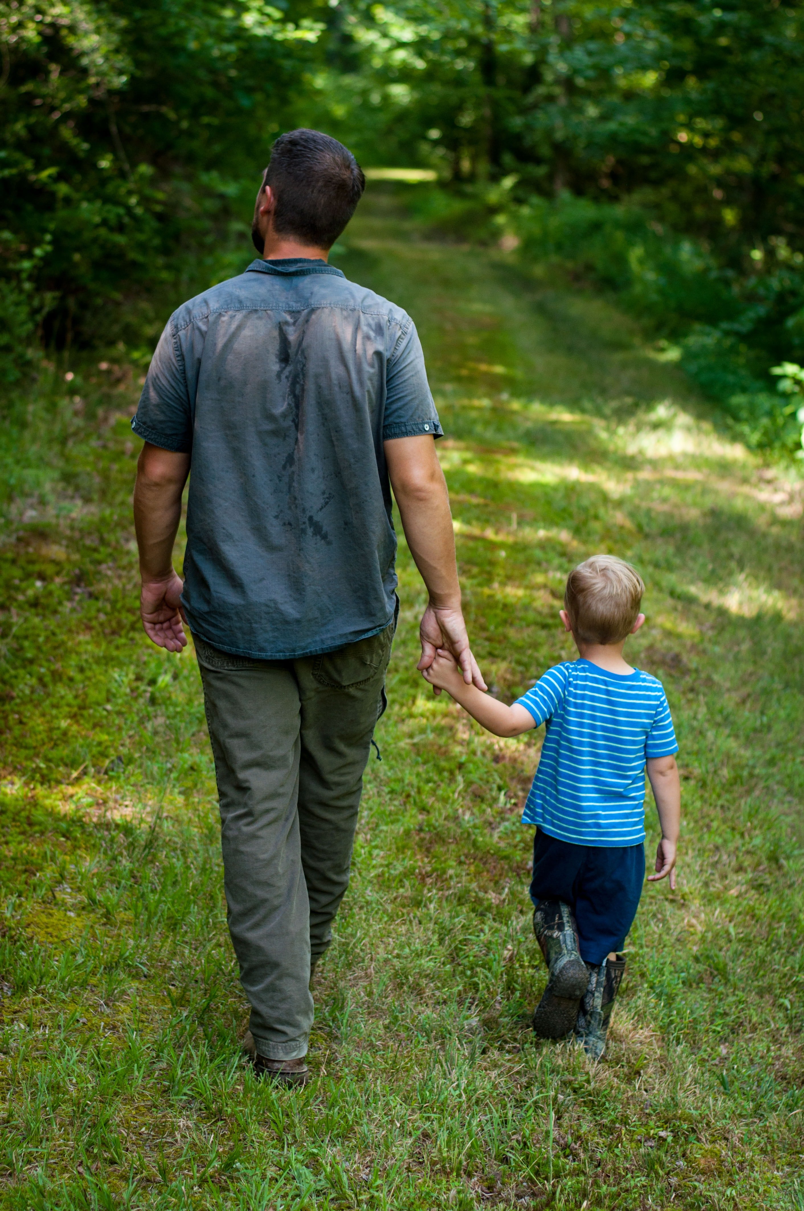 Un hombre y un niño pasean de la mano por el parque. | Foto: Unsplash