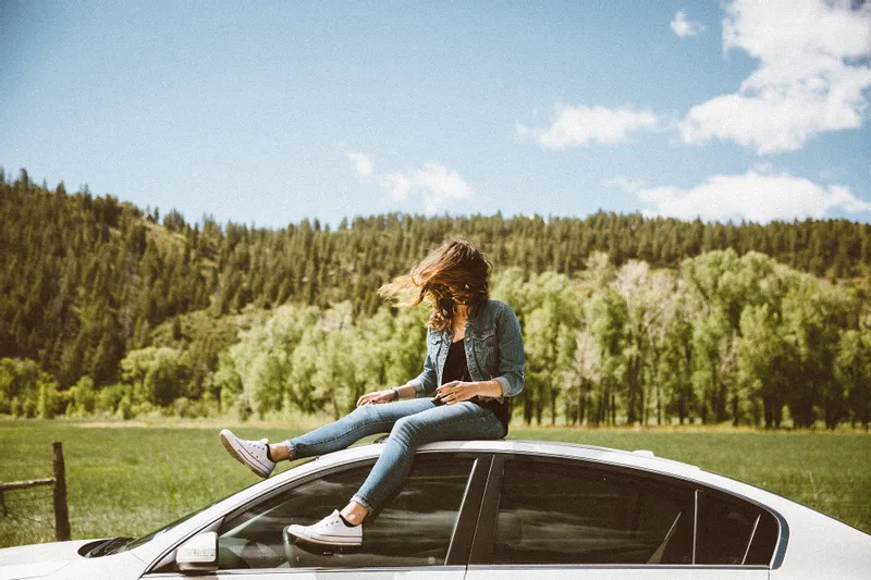 Une femme assise sur une voiture. | Photo: Getty Images