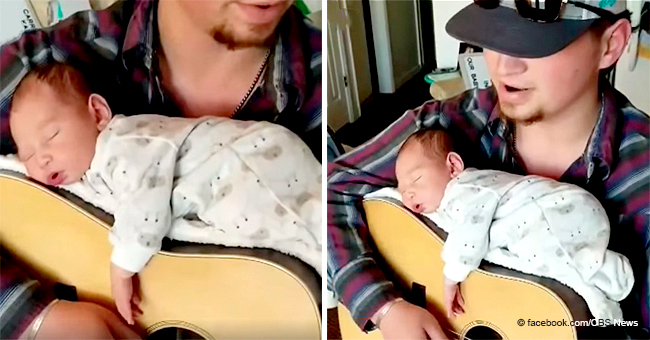 Country-Singing Father Lullabies His Newborn Daughter with His Guitar Playing While She Is on It