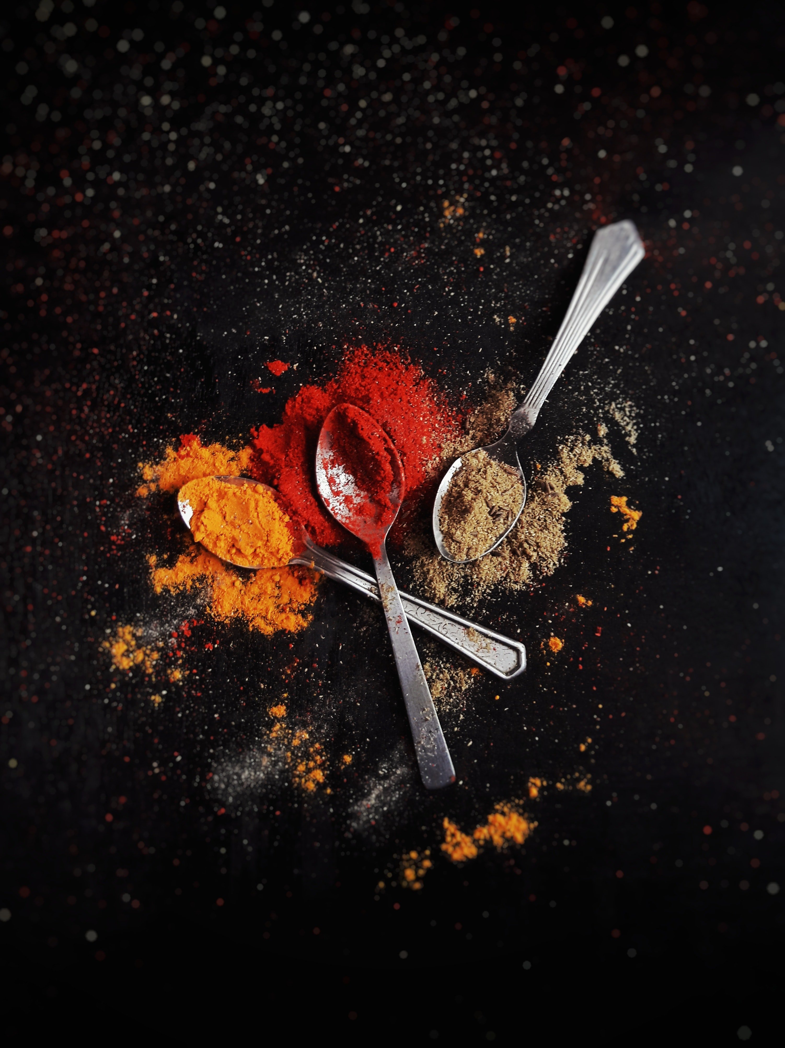 Three spoons with colorful spices. | Pexels