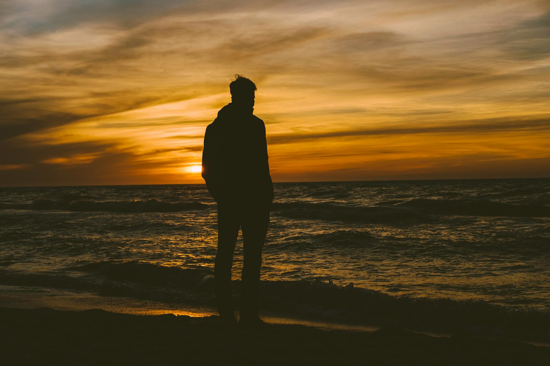 Silhouette of a man standing on the seashore | Source: Pexels