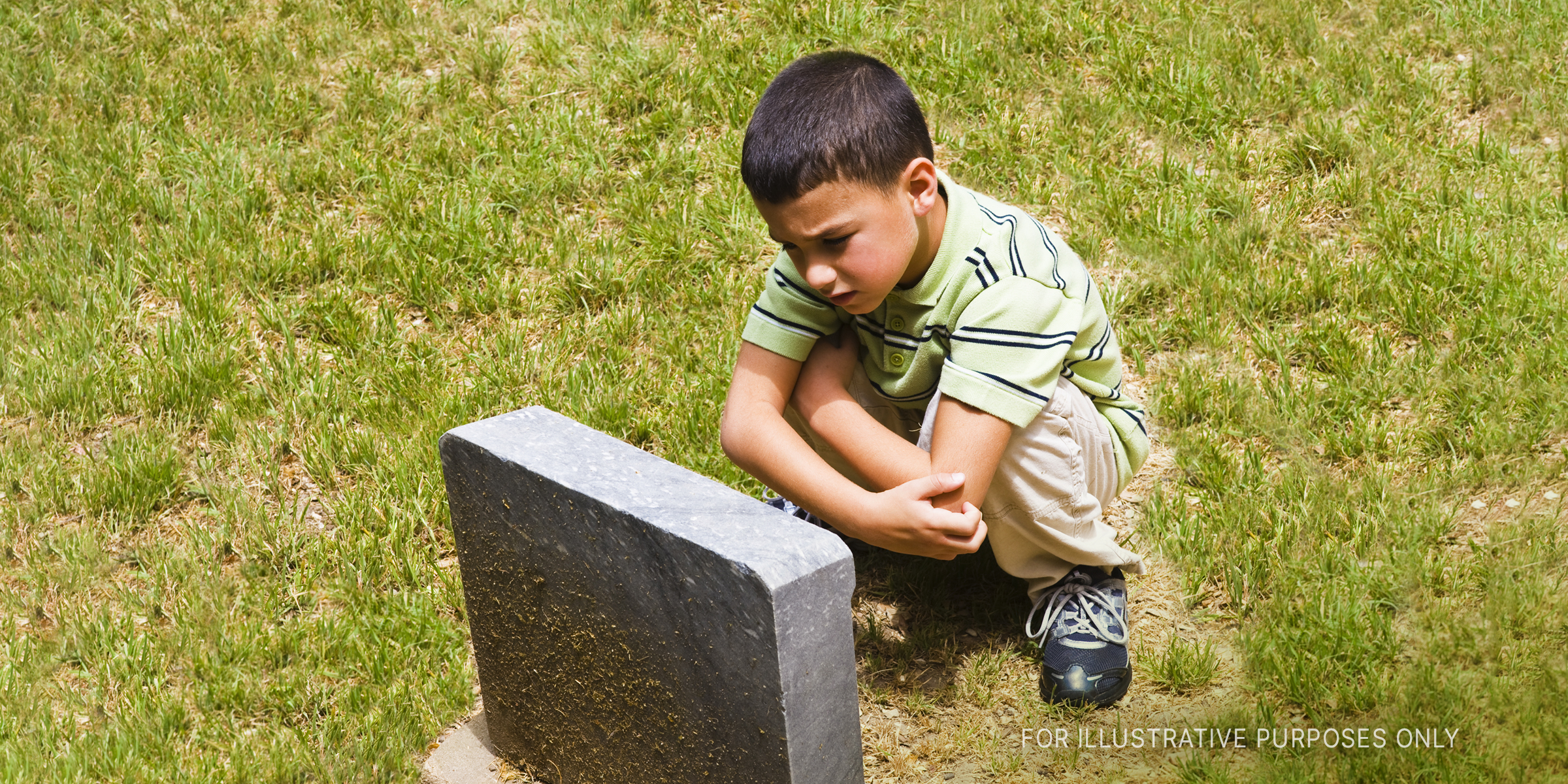 Sad Boy Near Grave. | Source: Getty Images