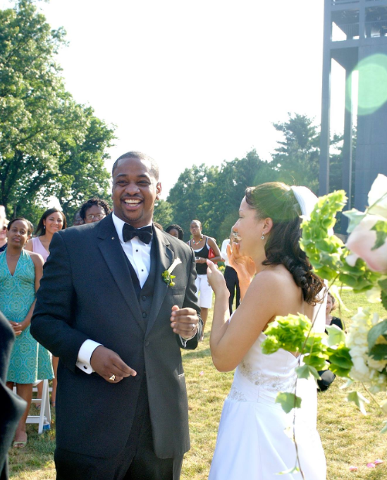 Justin and Cerina Fairfax smile during their outdoor wedding ceremony in June 2006 | Source: Facebook/justin.fairfax.2025