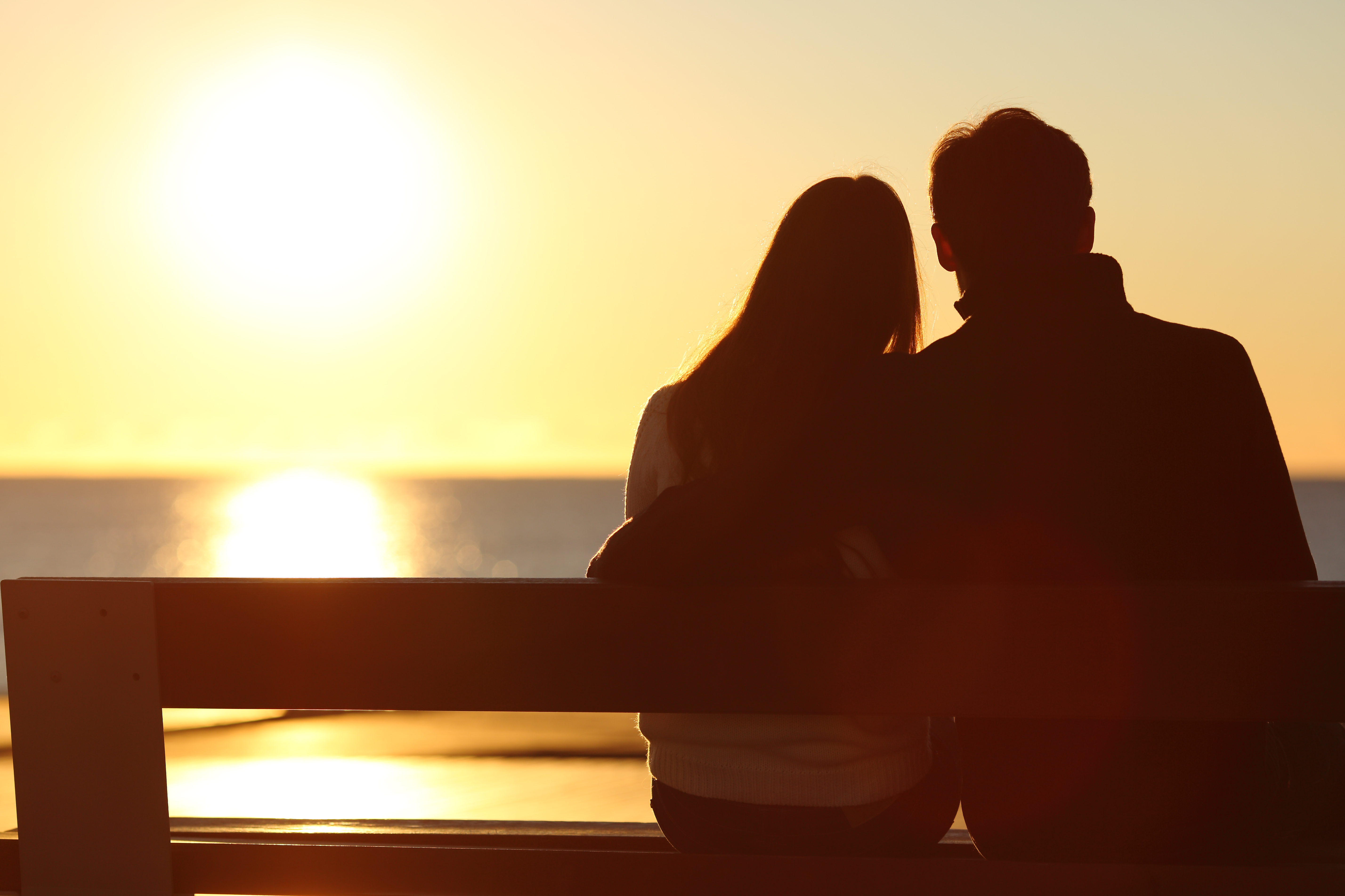 Silhouette of a couple watching the sun on the beach | Source: Shutterstock