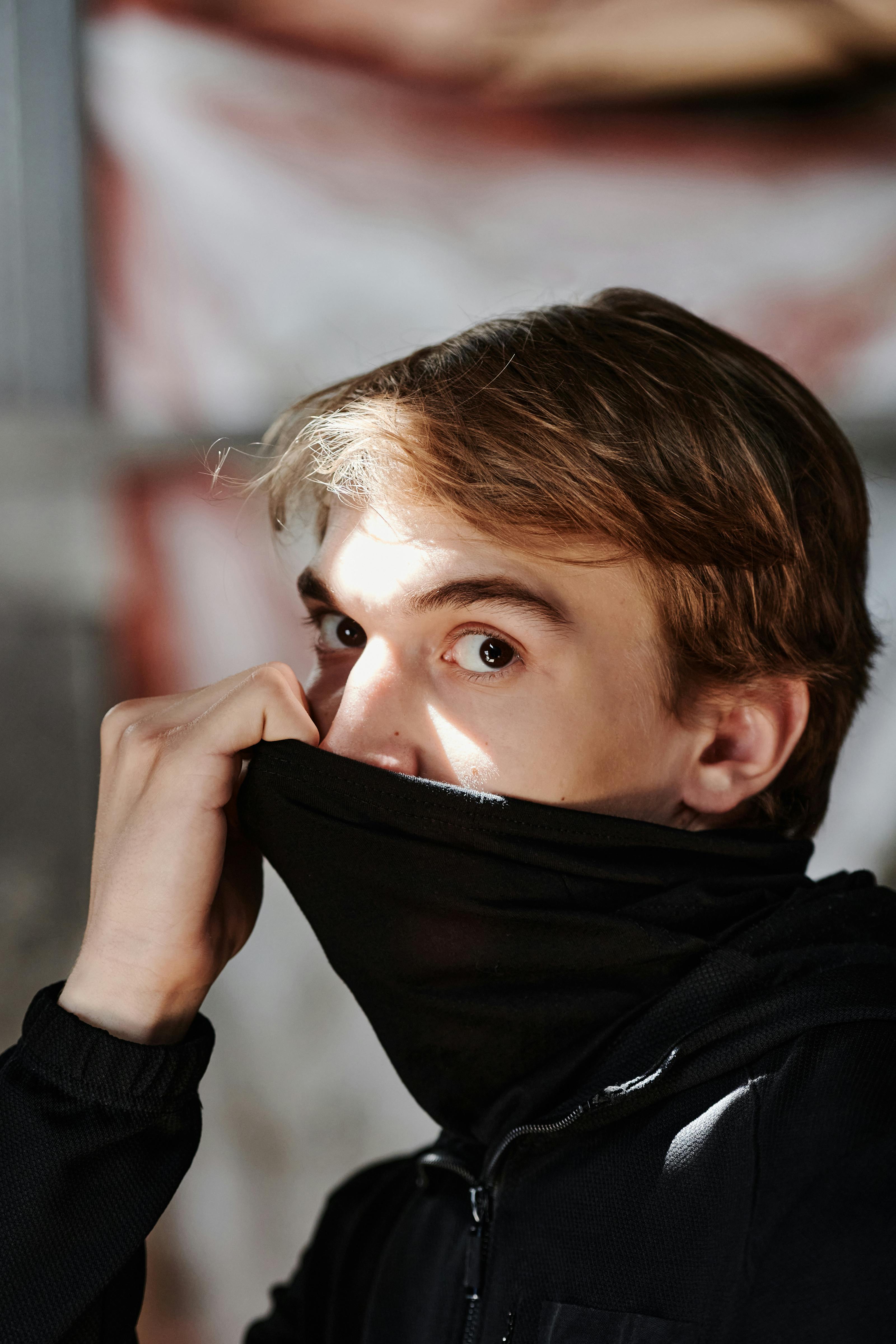 A shocked man covering his mouth with a black cloth | Source: Pexels