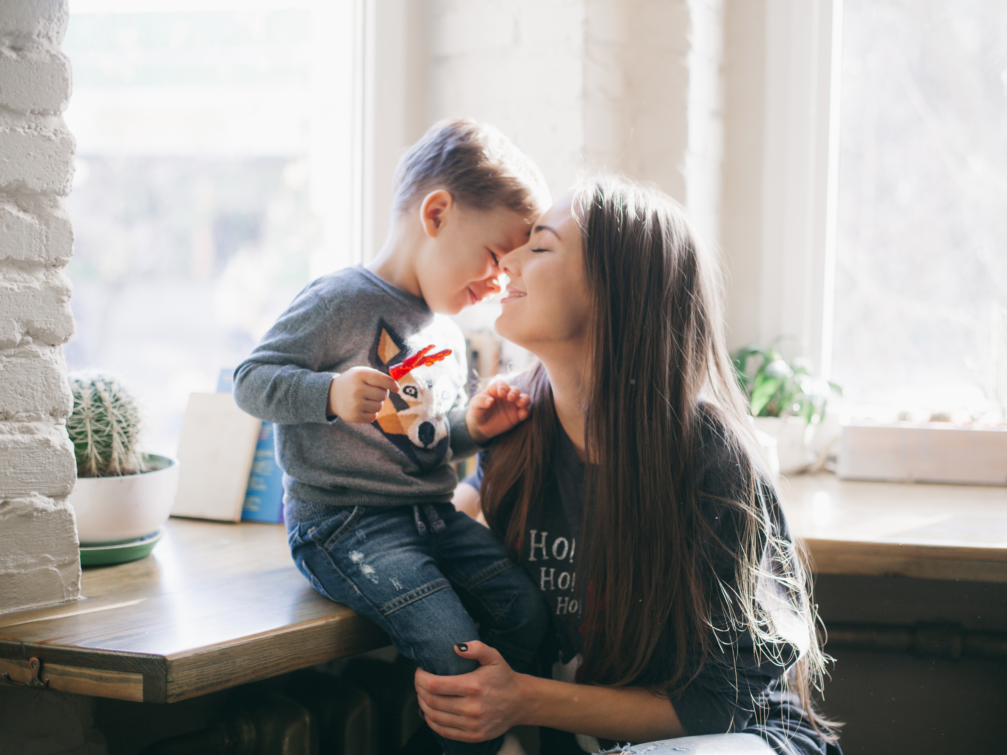 A woman and a little boy sharing a sweet moment by the window | Source: Shutterstock