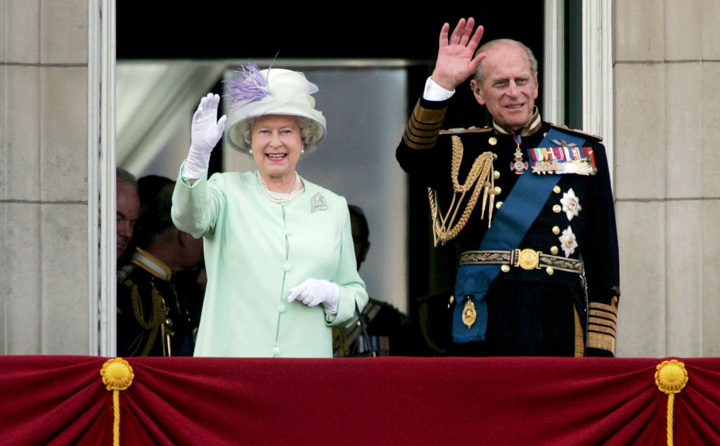 Queen Elizabeth II and Prince Philip wave to the public from the Buckingham Palace balcony on National Commemoration Day July 10, 2005 | Photo: Getty Images