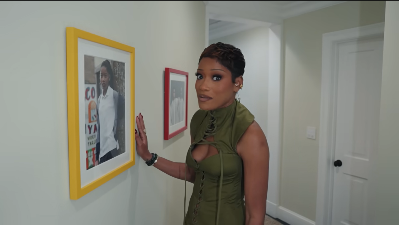 A sweet trip down memory lane! Palmer pauses in her hallway next to an iconic, yellow-framed childhood photo from her breakout role in "Akeelah and the Bee." | Source: YouTube/@Archdigest