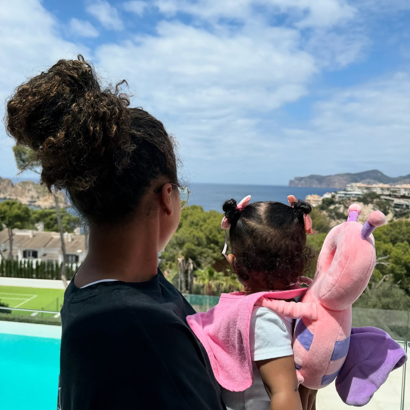 Naomi Osaka holding her daughter as they both look out into the distance, posted on January 1, 2025. | Source: Facebook/Naomi Osaka 大坂なおみ﻿