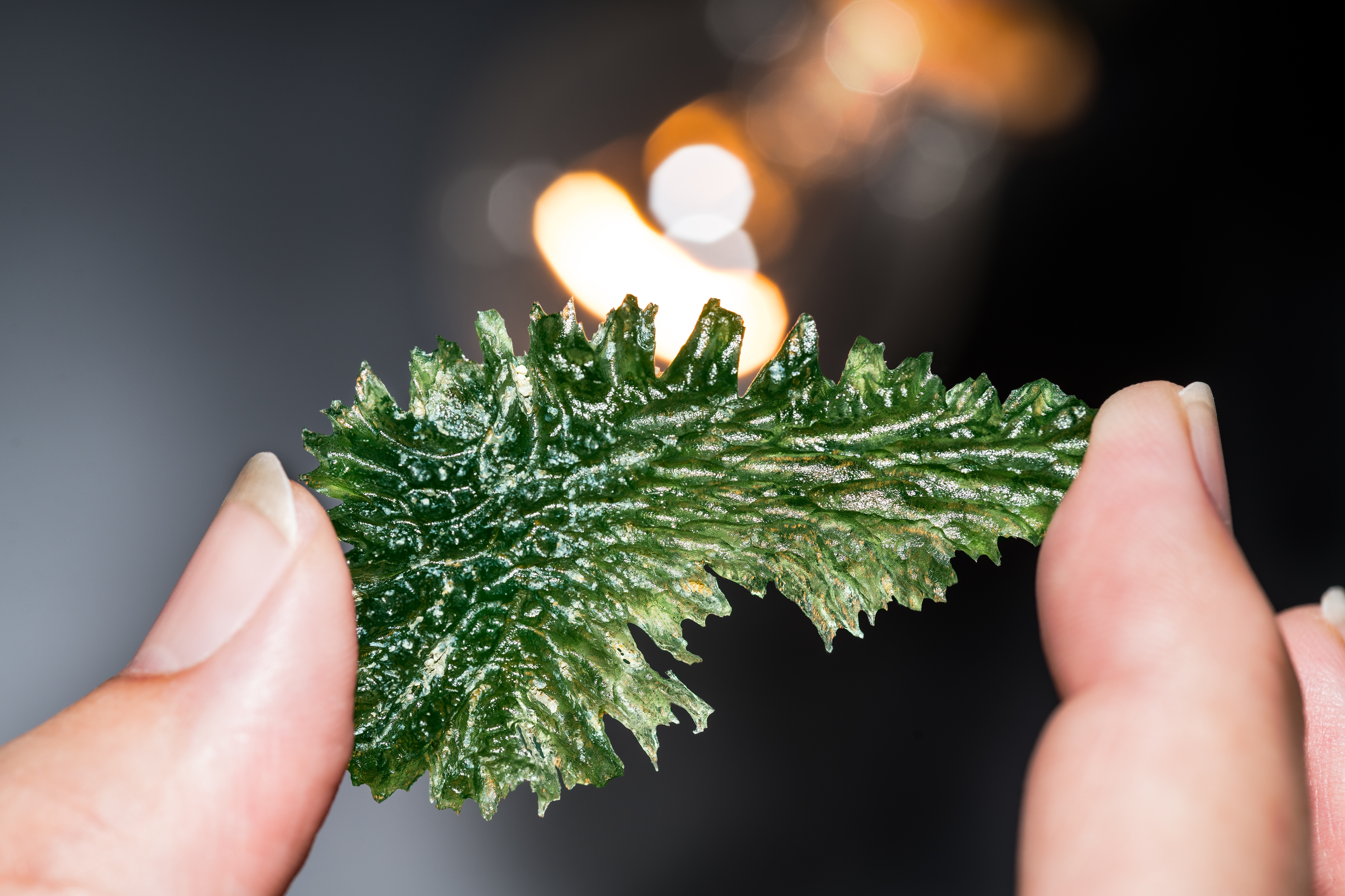 Photo of someone holding a piece of moldavite | Source: Shutterstock