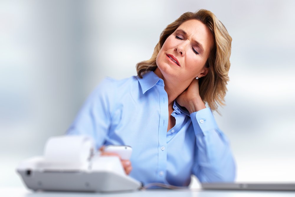 Geschäftsfrau, die Nackenschmerzen hat | Quelle: Shutterstock