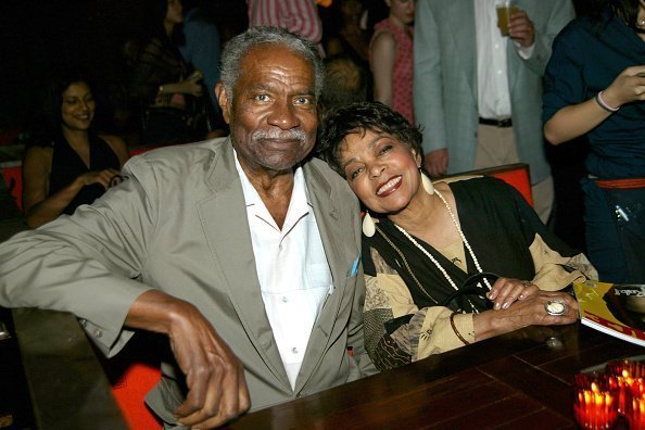 Activist Ossie Davis and actress Ruby Dee posing for a picture at a social gathering | Photo: Getty Images